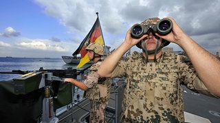 Deutsche Marine-Soldaten halten an Bord der Fregatte "Karlsruhe" an einem Maschinengewehr Wache