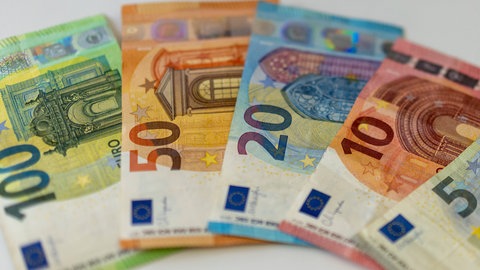 Symbolfoto: Es liegt jeweils ein Schein im Wert von 100, 50, 20 und 10 Euro auf einem Tisch.