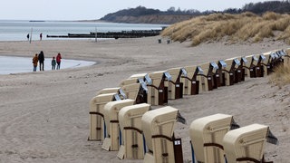 Wenige Spaziergänger sind auf der Halbinsel Fischland an der Ostsee unterwegs, die ersten Strandkörbe stehen bereit.