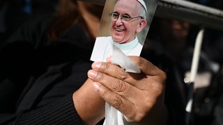 Eine Frau hält ein Bild von Papst Franziskus während eines Trauergottesdienstes für das verstorbene Oberhaupt der katholischen Kirche vor der Kathedrale von Buenos Aires.