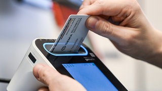 In der E-Health-Showpraxis der Kassenärztlichen Vereinigung Berlin wird eine Gesundheitskarte in ein Lesegerät gesteckt (Gestellte Szene).