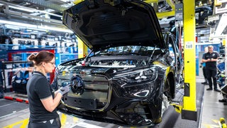 Mitarbeiter arbeiten in der der Halle 9 im Mercedes-Benz Werk Bremen an einem Fließband an Fahrzeugen vom Typ GLC