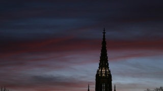 Eintrittskarte für eine Besichtigung: Der Turm des Ulmer Münsters steht im Abendrot.