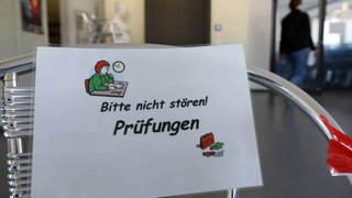 Vor Beginn der Abiturprüfung informiert ein Aushang vor der Aula in einem Gymnasium «Bitte nicht stören! Prüfungen»