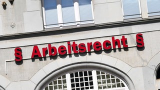Auf einem Gebäude steht der Schriftzug: § Arbeitsrecht §