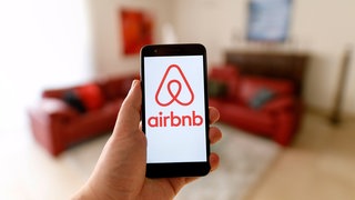 Das Logo des Wohnraumvermittlers Airbnb auf einem Mobiltelefon