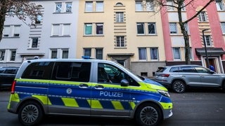 Ein Polizeiwagen fährt durch ein Wohnviertel. Am Donnerstag wurden in Baden-Württemberg 24 Wohnungen durchsucht.