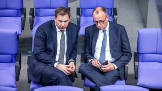 Lars Klingbeil, SPD Fraktionschef und Bundesvorsitzender, spricht mit Friedrich Merz, CDUCSU Fraktionsvorsitzender und CDU Bundesvorsitzender, im Bundestag. 