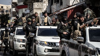 Angehörige der syrischen Sicherheitskräfte patrouillieren auf einer Straße in der Stadt Jableh in Syrien. Nach Assads Sturz morden Islamisten in Syrien.