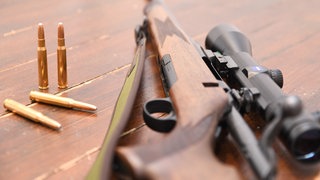Ein Jagdgewehr und Munition vom Kaliber 30-06 Springfield liegen auf einem Tisch. (Symbolbild)