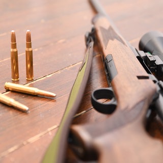 Ein Jagdgewehr und Munition vom Kaliber 30-06 Springfield liegen auf einem Tisch. (Symbolbild)