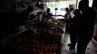 Stromausfall in halb Europa: In Spanien stehen Kunden in einem dunklen Ost- und Gemüseladen.Über die Ursache wird spekuliert. Sind Erneuerbare Energien mit-schuldig? Was dazu bislang bekannt ist.