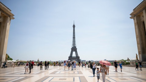 (Symbolbild) Touristen vor dem Eiffelturm in Paris am 18. Juni 2025.