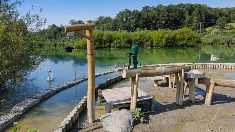 Wasserspielplatz am Lonesee mit Gänsen im Hintergrund.