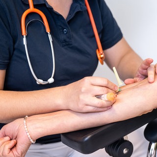Eine Patientin bei der Blutabnahme. Für eine bessere medizinische Versorgung sollen in Baden-Württemberg künftig "Community Health Nurses" sorgen.