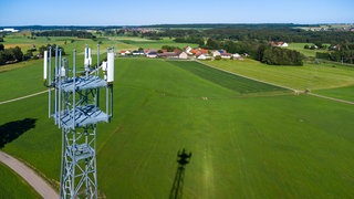 Ein Mobilfunkmast ragt aus der grünen Landschaft als Symbol für den schleppenden Ausbau von Mobilfunk in ländlichen Regionen. In Baden-Württemberg und Rheinland-Pfalz gibt es im Vergleich mit anderen Bundesländern die meisten Funklöcher.