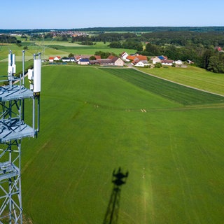 Ein Mobilfunkmast ragt aus der grünen Landschaft als Symbol für den schleppenden Ausbau von Mobilfunk in ländlichen Regionen. In Baden-Württemberg und Rheinland-Pfalz gibt es im Vergleich mit anderen Bundesländern die meisten Funklöcher.