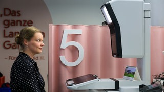 Eine junge Frau sitzt vor dem neuen Gerät, das digitale Passbilder macht. Im August läuft die Übergangsfrist aus, ab da müssen alle Passbilder digital sein. 