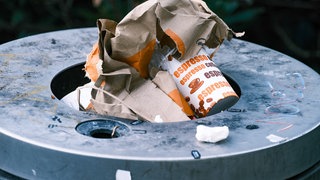 In vielen Mülleimern türmen sich Fast-Food-Einwegverpackungen - trotz Mehrwegangebotspflicht.