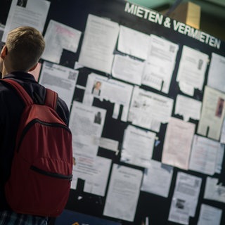 Mieten für Studierende: Wohnungsanzeigen an einem Schwarzen Brett in einer Mensa.