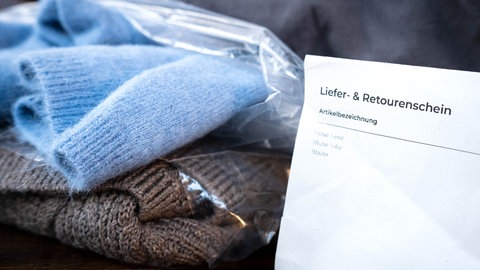 Ein Liefer- und Retourenschein liegt bei online bestellter Kleidung bei. Immer mehr Pakete werden wieder zurückgeschickt. Zuletzt war es fast jedes vierte Paket.