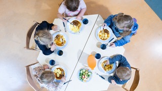 Kinder sitzen in einer Kita an einem Tisch. Bei der Kinderbetreuung für Kinder unter sechs Jahren gibt BW im Bundesschnitt am wenigsten Geld aus.