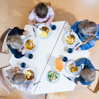 Kinder sitzen in einer Kita an einem Tisch. Bei der Kinderbetreuung für Kinder unter sechs Jahren gibt BW im Bundesschnitt am wenigsten Geld aus.