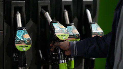 Ein Mensch tankt sein Auto an einer Tankstelle. Wegen des Iran-Kriegs steigen die Spritpreise seit Tagen an. In Deutschland kostet der Liter Super und Diesel über 2 Euro.
