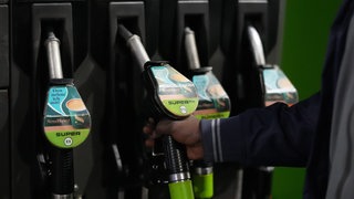 Ein Mensch tankt sein Auto an einer Tankstelle. Wegen des Iran-Kriegs steigen die Spritpreise seit Tagen an. In Deutschland kostet der Liter Super und Diesel über 2 Euro.