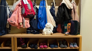 In der Garderobe in einer Kindertagesstätte hängen Kinderjacken.