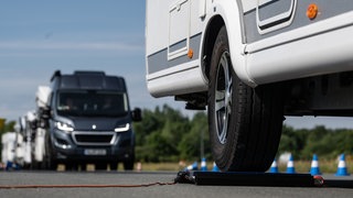 Ein Wohnmobil steht bei einer Wiegeaktion für Wohnmobile auf einer Waage. Bei Überladung drohen harte Strafen.