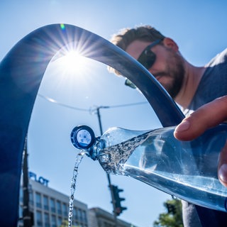 Ein Tourist aus Stuttgart füllt seine Wasserflasche am öffentlichen Wasserspender. Die Sommer werden immer heißer, doch aus Deutschlands Städten verschwinden die Bäume - knapp eine Million - und immer mehr Flächen sind versiegelt - ergibt der Hitze-Check der Deutschen Umwelthilfe.