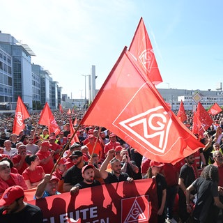 An einem Eingang zum Mercedes-Benz Werk demonstrieren mehrere tausend Mitarbeiter des Automobilherstellers Mercedes-Benz mit Fahnen der Gewerkschaft IG Metall gegen den  Sparkurs.