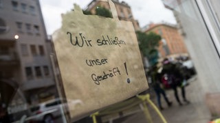 Hinweisschild auf Schaufenster: Wir schließen unser Geschäft