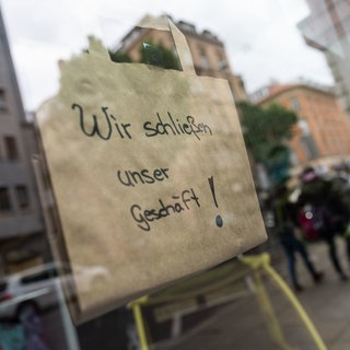 Hinweisschild auf Schaufenster: Wir schließen unser Geschäft