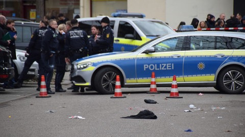 Polizisten stehen auf einer Straße.
