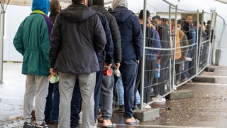 In der Landeserstaufnahmestelle (LEA) in Ellwangen warten Flüchtlinge in einer Schlange vor der Essensausgabe.
