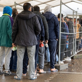 In der Landeserstaufnahmestelle (LEA) in Ellwangen warten Flüchtlinge in einer Schlange vor der Essensausgabe.