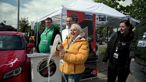 Anstoßen auf den Verbrenner: "Alkoholfrei und E-Auto-frei", sagt die Motorsportbegeisterte Birgit Zimmermann.