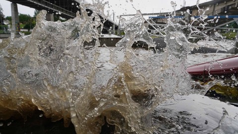 Am Neckar in Stuttgart spritzt das Wasser am Flussufer hoch.