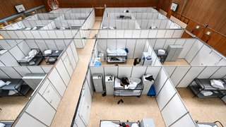 Eine Sporthalle mit kleinen Kabinen und Betten für Flüchtlinge.