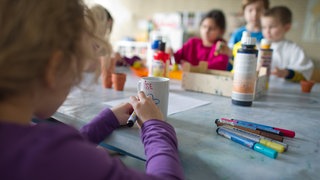 Grundschüler sind in einem Hort mit Bastelarbeiten beschäftigt.