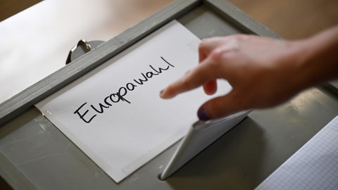 Ein Wahlschein wird im Sigmaringer Stadtteil Laiz in eine Wahlurne geworfen.