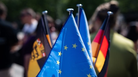 Die baden-württembergischen Landesflagge, die Flagge der Europäischen Union und die Deutschlandflagge.