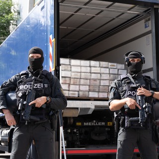 Polizisten sichern einen Polizei-Lastwagen mit sichergestelltem Kokain auf der Ladefläche.