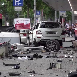 Ein Auto ist von hinten an der Unfallstelle in der Nürtinger Innenstadt inmitten von Trümmerteilen zu sehen.