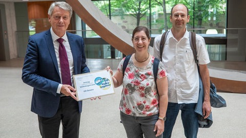 Ministerialdirigent Andreas Schütze (links), Leiter der Abteilung 1 im Innenministerium von Baden-Württemberg, nimmt von Marita Raschke (Mitte) und Ralf Kittel (rechts), Vertreter der Elterninitiative, einen Umschlag mit einem Antrag auf Durchführung eines Volksbegehrens bezüglich des G9-Gesetzes entgegen. 