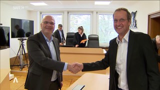 Zwei Männer in Anzug geben sich die Hand