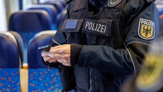 Bundespolizist kontrolliert in einem Zug.