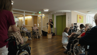 Eine Musikerin spielt pflegebedürftigen Heimbewohnern in Winnenden Musik vor.